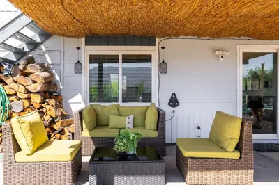 a porch with two chairs and a couch and a table at Magical Lake View in Peachland