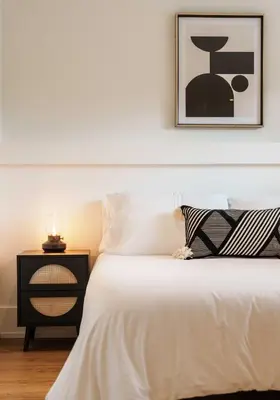 a bedroom with a white bed and a black nightstand at 4 Bed Home Along River Near DT AC Hot Tub in Calgary