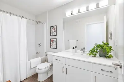a white bathroom with a toilet and a sink at Magnificent Stylish Escape in Bélanger