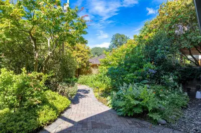 a garden with a brick path and plants at Garden Suite near Jericho Beach in Vancouver
