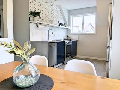 a kitchen with a wooden table with a vase on a table at Top Floor Mountain View Escape in Canmore