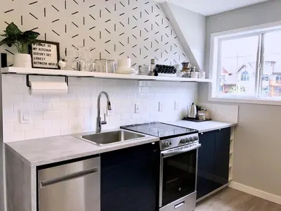 a kitchen with a sink and a stove and a window at Top Floor Mountain View Escape in Canmore