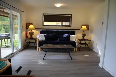 a living room with a couch and a tv at Taylor Lake Resort BC in Lone Butte