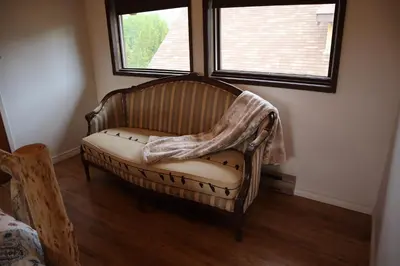 a chair sitting in a room with two windows at Taylor Lake Resort BC in Lone Butte