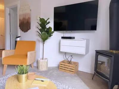 a living room with a fireplace and a tv on the wall at Canmore Top Floor Loft-Style Retreat in Canmore