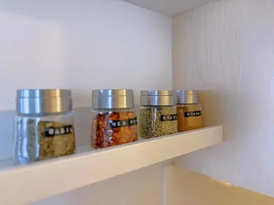 four jars of spices on a shelf in a kitchen at Canmore Top Floor Loft-Style Retreat in Canmore