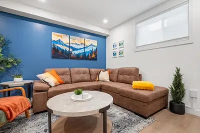 a living room with a couch and a table at Meadowstone Suite 3BD 3 TVs Near Spruce Meadows in Calgary