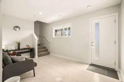 a white living room with a couch and stairs at Large Single Family 3 Bedroom House with Air Conditioner, Garage and Lake View in Calgary