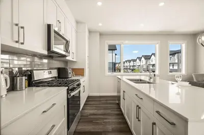 a kitchen with white cabinets and a large window at Large Single Family 3 Bedroom House with Air Conditioner, Garage and Lake View in Calgary