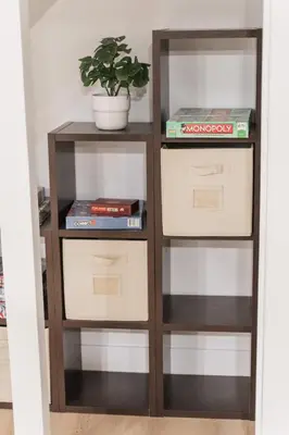 a book shelf with three drawers and a plant at Play & Stay - Downtown Sleeps 10 in Edmonton