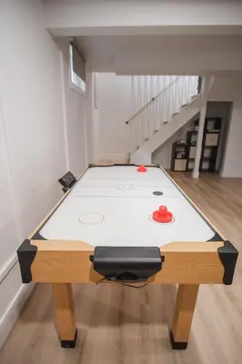 a ping pong table in the middle of a room at Play & Stay - Downtown Sleeps 10 in Edmonton