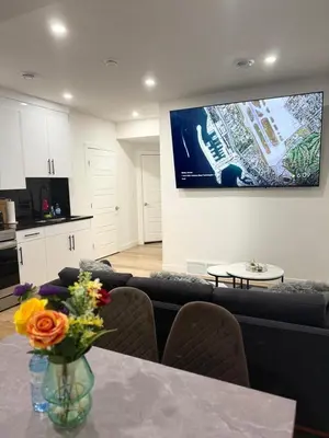 a living room with a vase of flowers on a table at Cozy 2-Bedroom Basement Suite Just Minutes from the Airport in Calgary