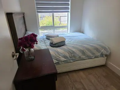 a bedroom with a bed with a table and a window at Private Room in Vibrant Vancouver - with share living room and kitchen in Vancouver