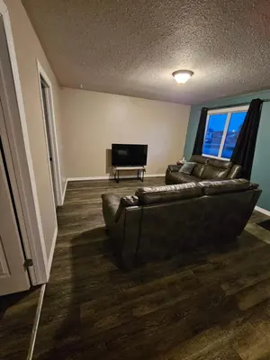 a living room with a couch and a flat screen tv at Cozy Bungalow