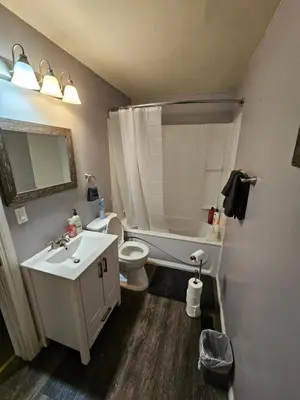 a bathroom with a toilet and a tub and a sink at Cozy Bungalow