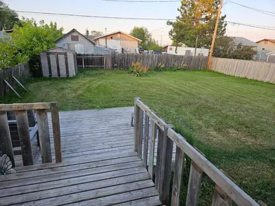 a wooden walkway leading to a yard with a fence at Cozy Bungalow