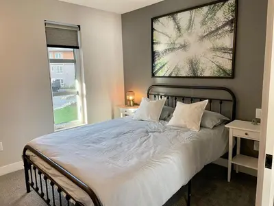 a bedroom with a bed with a picture on the wall at Parksville Townhome 2 bedroom pool gym in Parksville
