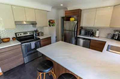 a kitchen with stainless steel appliances and a counter top at Mid-Century Modern Apartment at Horner Park in Victoria