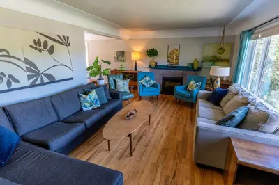 a living room with blue couches and a table at Mid-Century Modern Apartment at Horner Park in Victoria