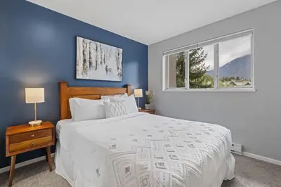 a bedroom with a large bed and a window at 2BR in Deer Lodge, Epic Location, Private Covered Patio, Free Parking in Whistler