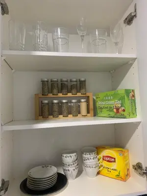 a kitchen pantry with plates and glasses and a box of food at Modern 1BR Entire Suite Near Airport in Calgary
