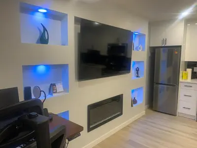 a living room with a fireplace and blue lights at Modern 1BR Entire Suite Near Airport in Calgary