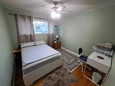 a bedroom with a bed and a desk and a window at Private Bedroom at Riverfront House in Kamloops