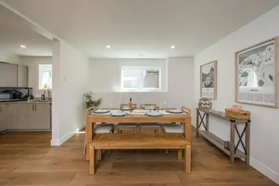 a dining room with a table and a kitchen at Forest Haven on the Ridge in Prince George