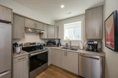 a kitchen with wooden cabinets and stainless steel appliances at Forest Haven on the Ridge in Prince George