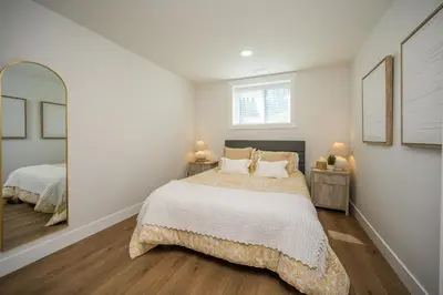 a bedroom with a bed and a mirror at Forest Haven on the Ridge in Prince George