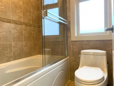 a bathroom with a toilet and a tub and a window at Sakura Stay two bedrooms with a private bathroom in Richmond