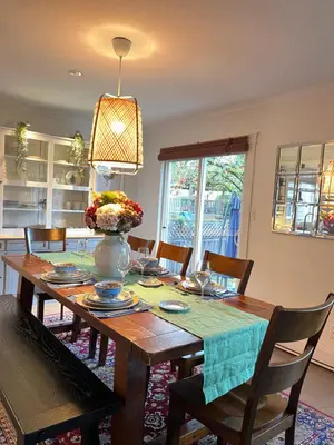 a dining room table with a vase of flowers on it at LF Guesthouse in Nanaimo