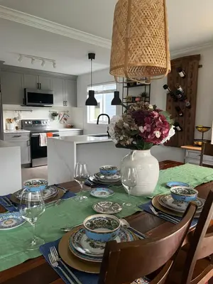 a dining room table with a vase of flowers on it at LF Guesthouse in Nanaimo