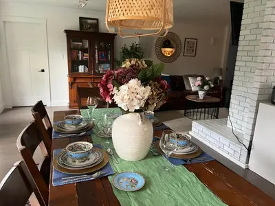 a dining room table with a vase of flowers on it at LF Guesthouse in Nanaimo