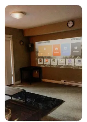 a room with a large screen with a clock on a wall at Lower suite in family friendly townhome in Victoria