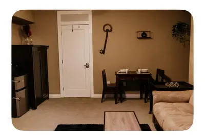 a living room with a table and a couch at Lower suite in family friendly townhome in Victoria