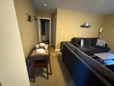 a living room with a couch and a table at Lower suite in family friendly townhome in Victoria