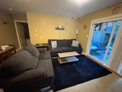 a living room with a couch and a table at Lower suite in family friendly townhome in Victoria