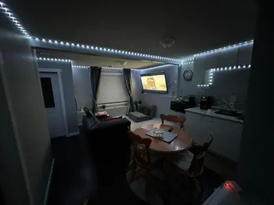 a room with a table and a kitchen with lights at ComfyComfort in Calgary