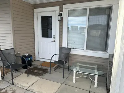 a porch with two chairs and a table in front of a door at ComfyComfort in Calgary