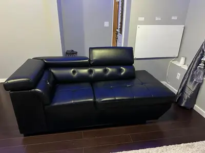 a black leather reclining couch in a room at ComfyComfort in Calgary