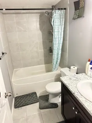 a bathroom with a tub and a toilet and a sink at ComfyComfort in Calgary