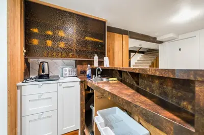 a kitchen with white cabinets and a counter top at Picturesque room surrounded by flowers with share spaces in Vancouver