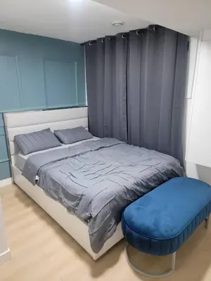 a bedroom with a bed with a blue wall at Shiloh Residence in Edmonton