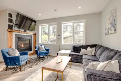 a living room with a couch and a fireplace at 4-bedroom with Game Room & Hot Tub in Fernie