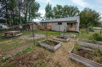 a garden with four raised beds in front of a house at Pet-Friendly Invermere Home with Firepit by StayIn in Lake Windermere