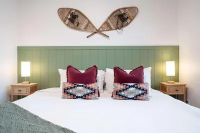 a bed with two pillows and a heart on the wall at Huckin' Harry's in Revelstoke