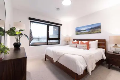 a bedroom with a large bed and a window at Huckin' Harry's in Revelstoke