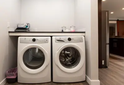 a laundry room with a washer and dryer at Cozy 1-Bedroom Retreat in the Heart of Langford in Victoria