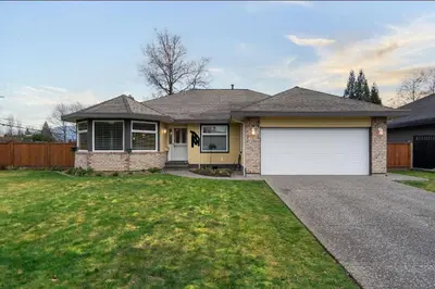 a house with a white garage in a yard at Guest Suite in Maple Ridge in Maple Ridge District Municipality